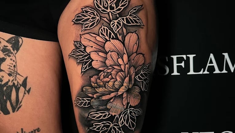 Large floral thigh tattoo with bold blackwork shading
