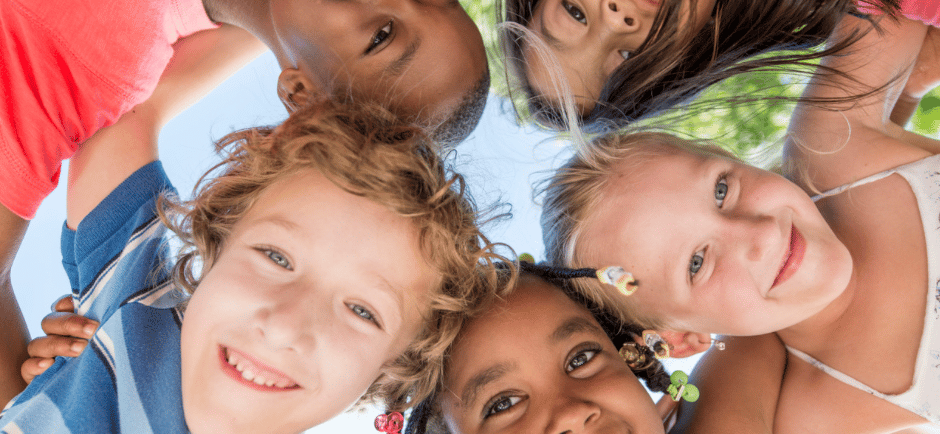 Group of smiling kids looking down at the camera