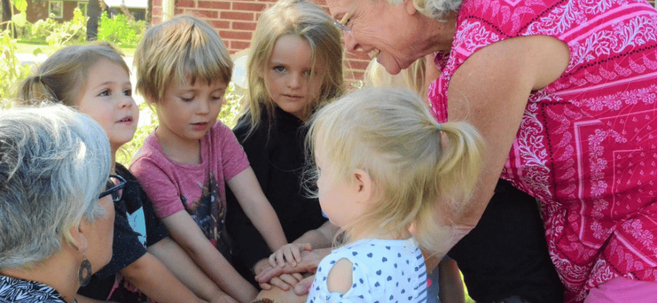 An older woman helps out at the preschool
