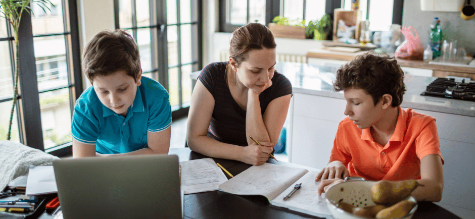 Mom helps her teen boys with their homeschool assignments
