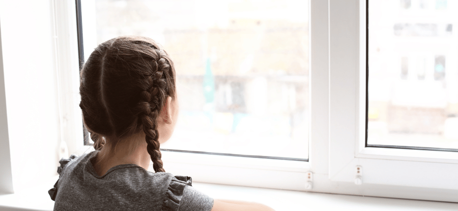 Young girl looking at out the window