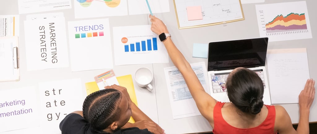two people sitting at a table with papers and papers