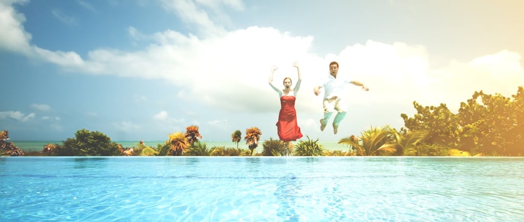 Couple jumping into a swimming pool