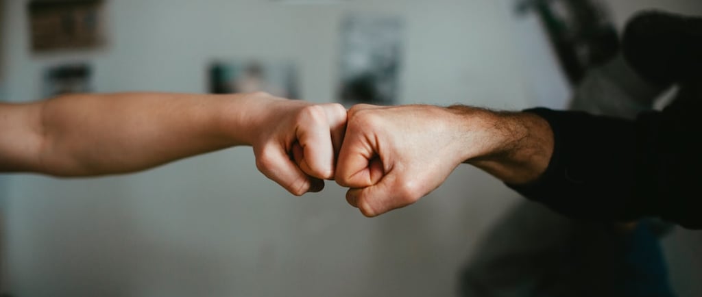 Empty nester parent giving fist bump to their adult child