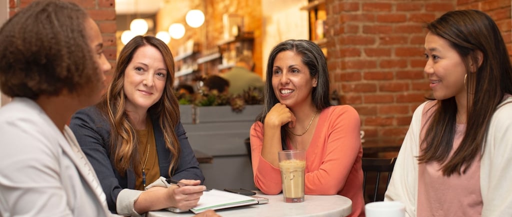 Four women sat together in a cafe talking