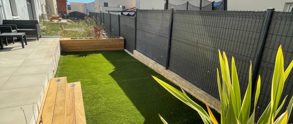 Aménagement de petit jardin avec gazon synthétique et terrasse réalisé par paysagiste à Montpellier