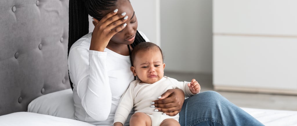 Overwhelmed mother holding her baby, illustrating the struggles of postpartum depression and maternal mental health challenge