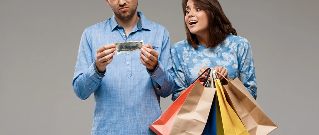 Woman with purchases, man holding last money over grey wall