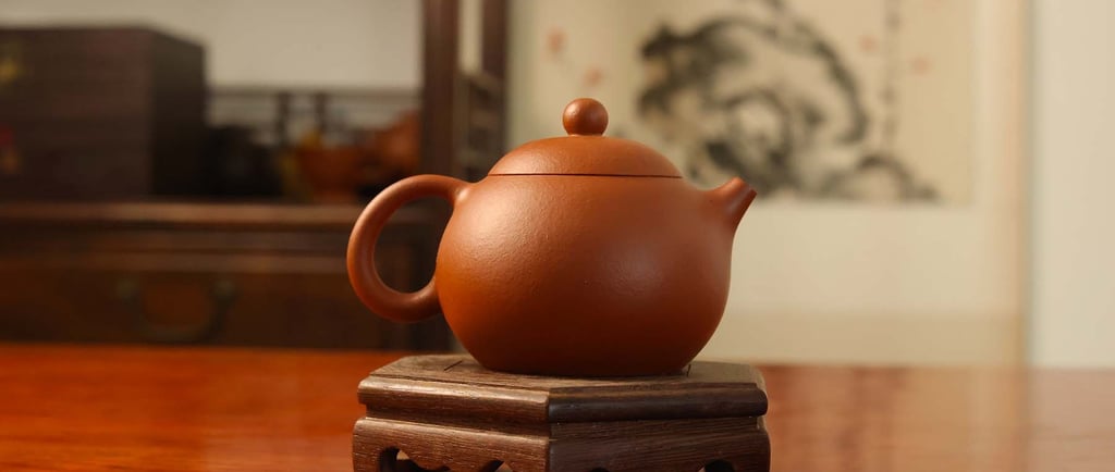 Round-shaped teapot placed on a wooden stand