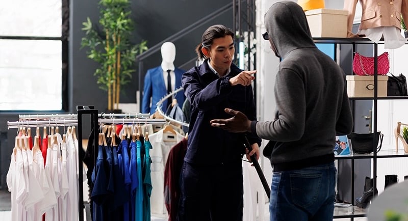 Retail security personnel confronting a suspected shoplifter, highlighting the importance of AI-powered surveillance cameras