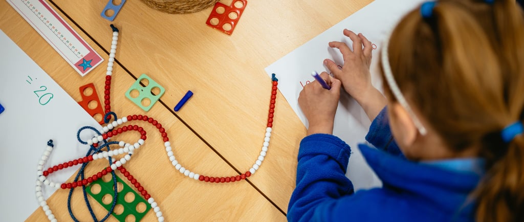 a child's hands are writing on a paper