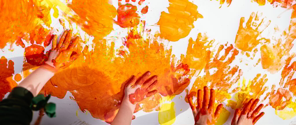 a group of children's hands and hands painted with orange paint