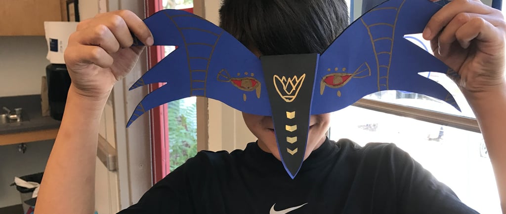 student holding mask in front of face