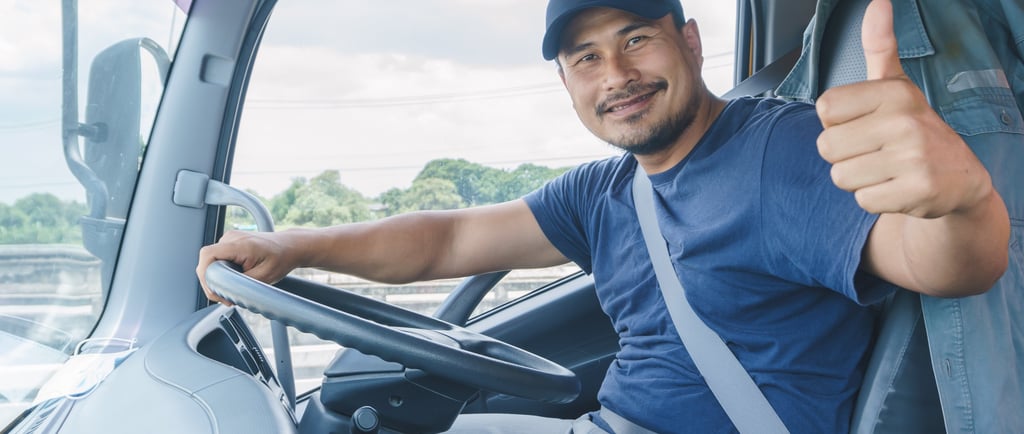 a man in a blue shirt is sitting in a truck