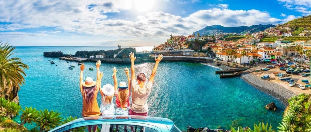Family on a summer road trip overlooking Camara de Lobos coastal village in Madeira, Portugal.