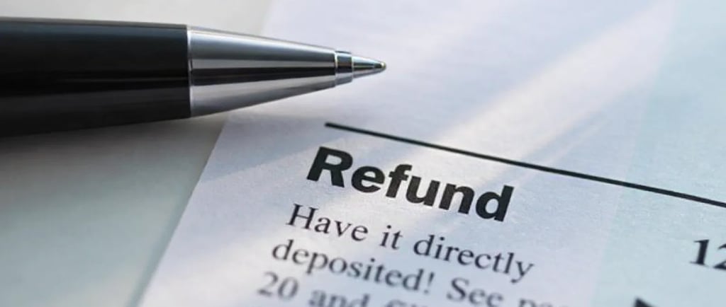 A close-up of a pen pointing to a tax refund direct deposit section on a paper document.