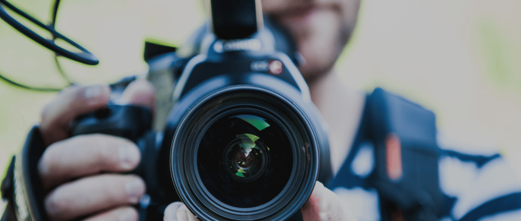 a man holding a camera and taking a picture of a camera