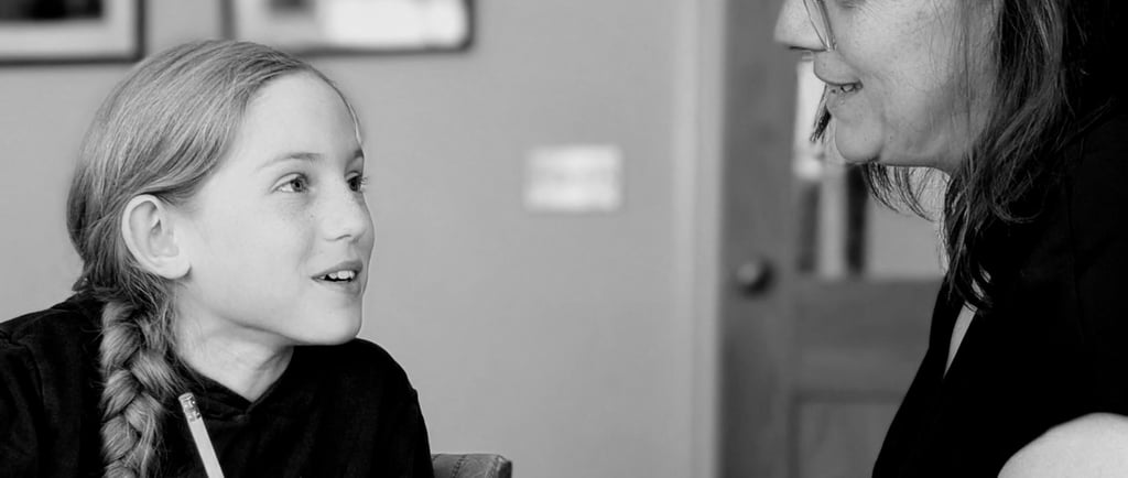 A primary school girl smiles at her teacher during a private tutoring session for Key stage 2 11+