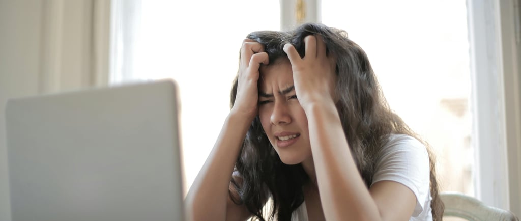 a woman sitting at a table with a laptop computer