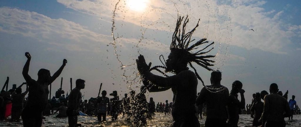 a man with dreadlocks and dreadlocks standing in the water