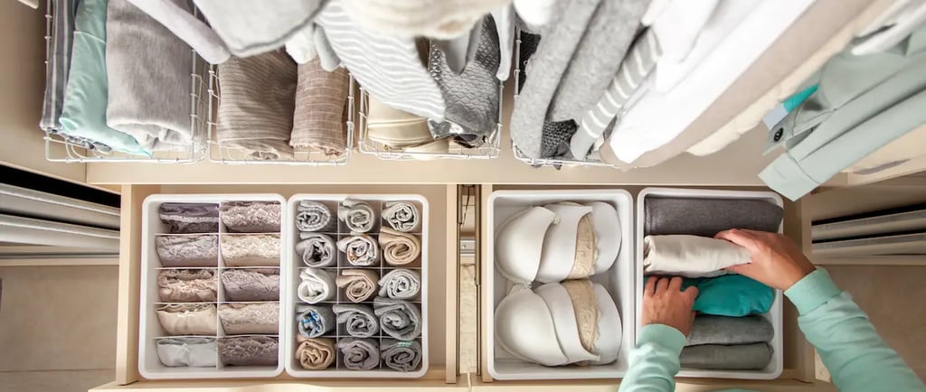 Organized closet drawers with folded clothes, bras, and socks using dividers for home storage.