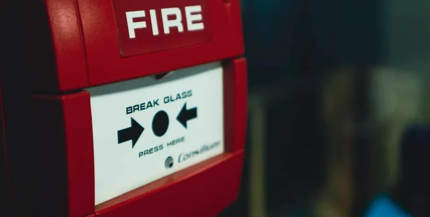 Red emergency fire alarm pull station with break glass instructions for building safety.