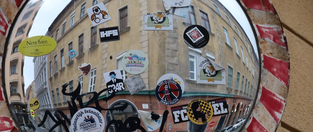 A traffic mirror full of stickers at the corner of Klauzál tér and Dob utca, Budapest, Hungary