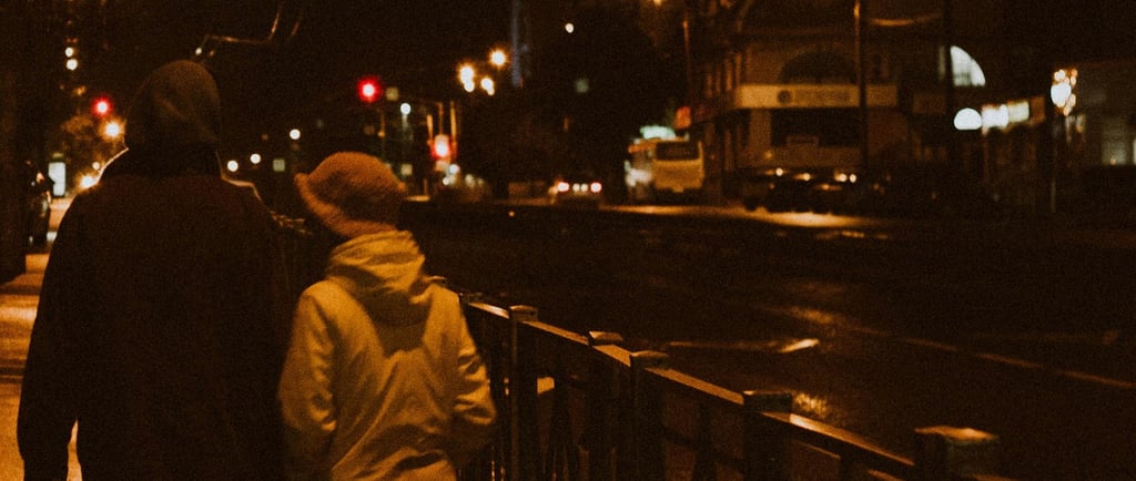 a couple walking down a street at night