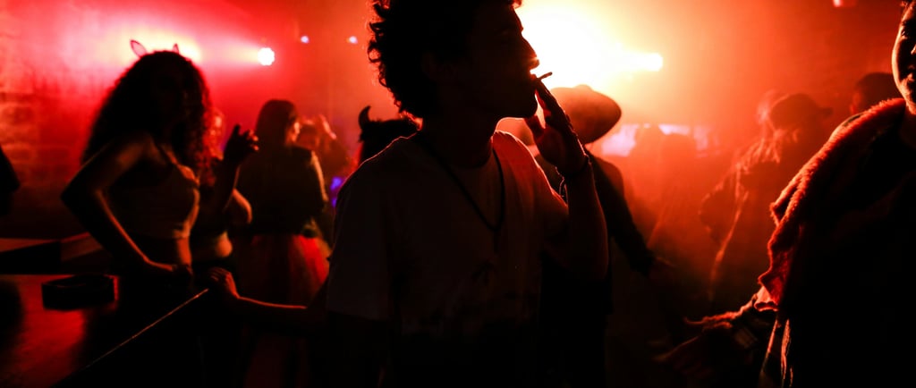 Silhouette de femme dans une soirée aux lumières colorées, ambiance nocturne et sensuelle