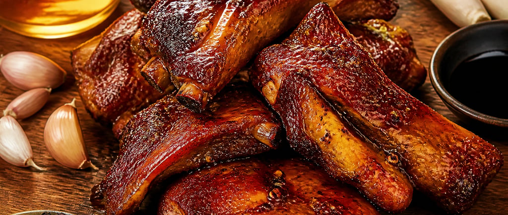 A platter of honey glazed BBQ pork ribs with garlic, lemongrass, honey, and black peppercorns.