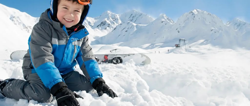 a young boy sitting in the snow with his snowboard el colorado chile