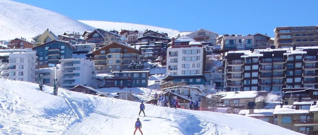 a group of people skiing down a hill la parva and valle nevado