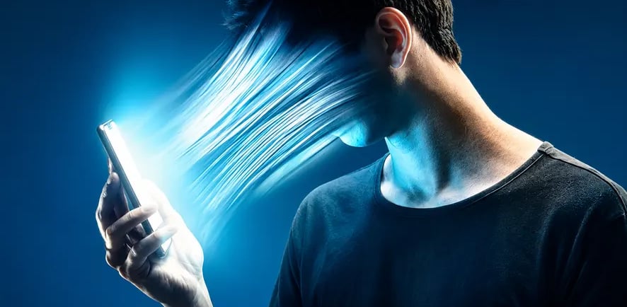 Imagem representando a dependência tecnológica: feixe de luz azul de um smartphone sugando o rosto