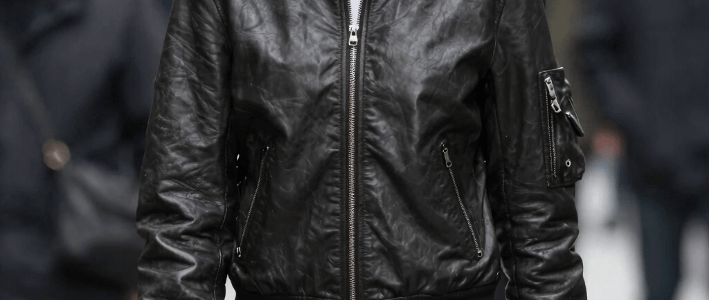 Man models bomber jacket with a printed face.