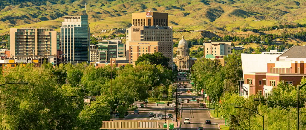 A scenic view of the Boise Idaho skyline and state capitol building with the green foothills in the background.