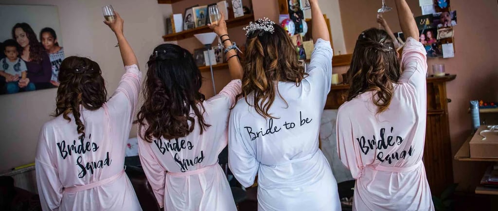 bride and bridemaid raising a glass of champagne