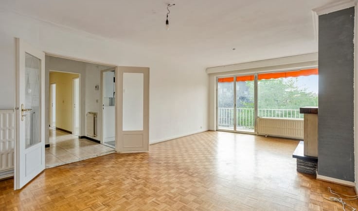 a living room with a wooden floor and a balcony