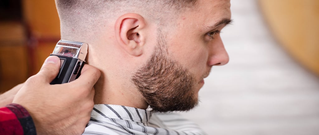 Barber giving a sharp skin fade haircut at a men's barber shop in Calgary AB