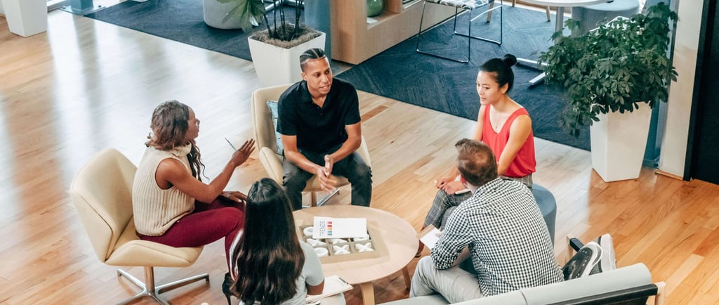 Small group meeting in a modern workspace discussing business strategy.