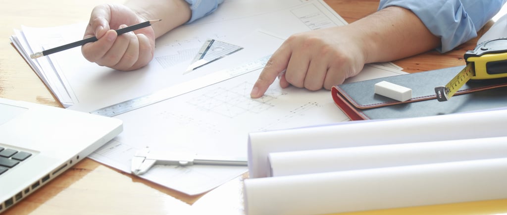 Inventor reviewing patent documents and technical drawings while preparing for the patent process
