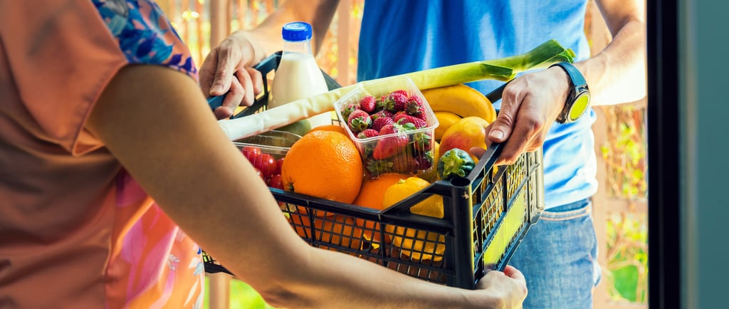 a man and woman holding a basket of fruit