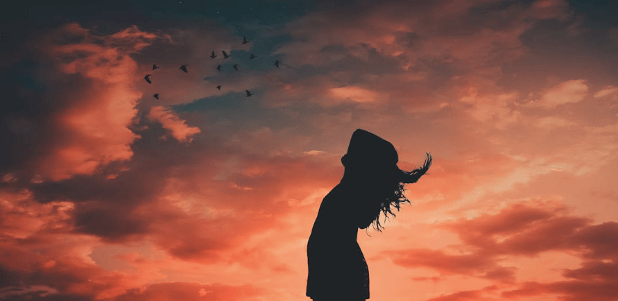 Woman standing before a dramatic red sky