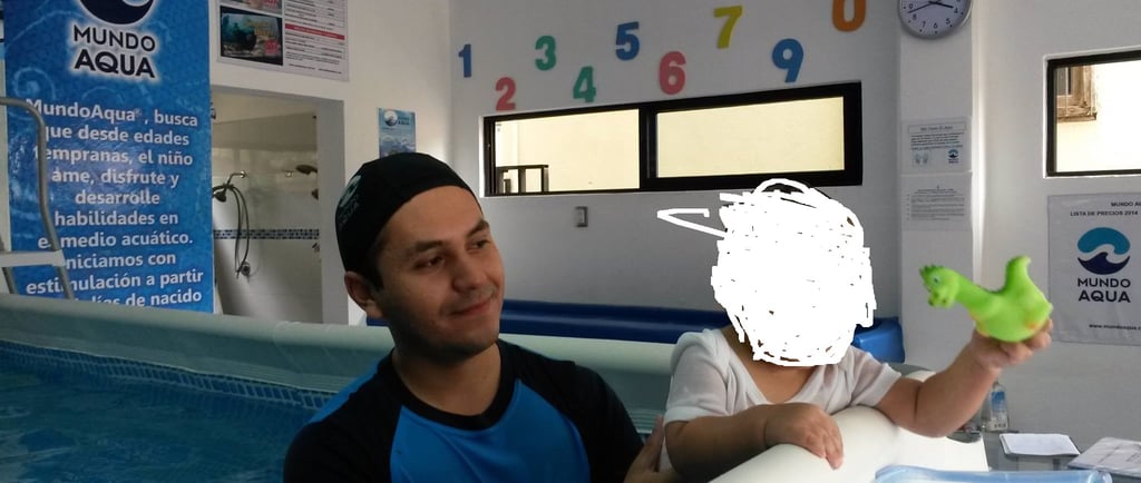 a man holding a green frog toy in front of a pool