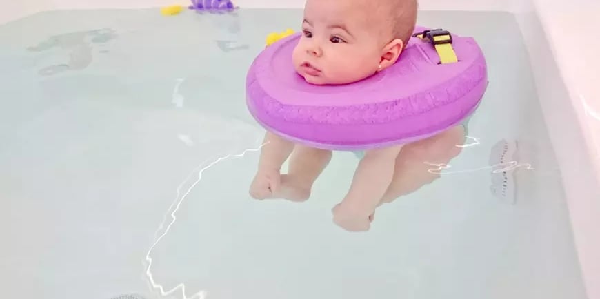 a baby in a tubtub with a purple float ring