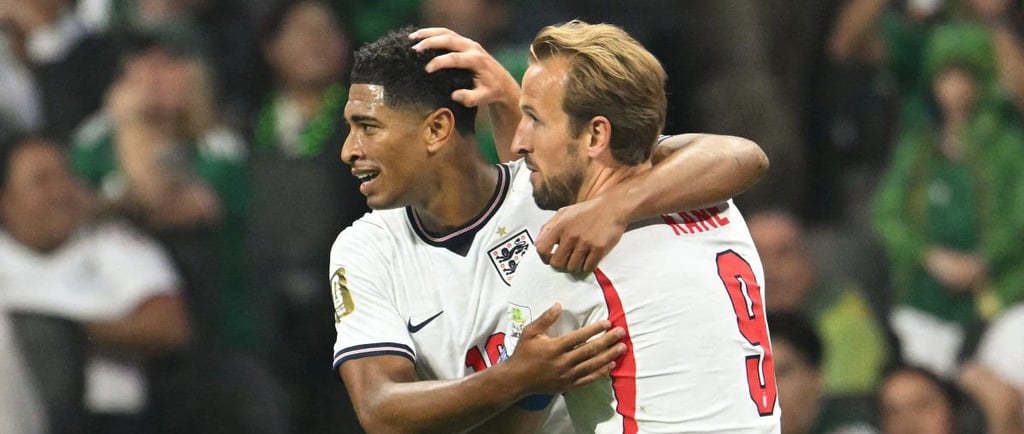 England soccer players Jude Bellingham and Harry Kane celebrate a goal together on the pitch.