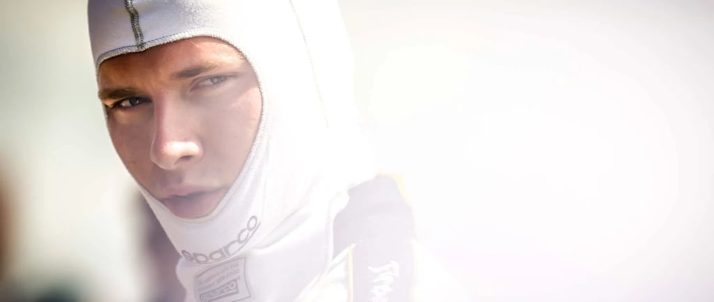 Professional race car driver wearing a white Sparco fireproof balaclava and racing suit.