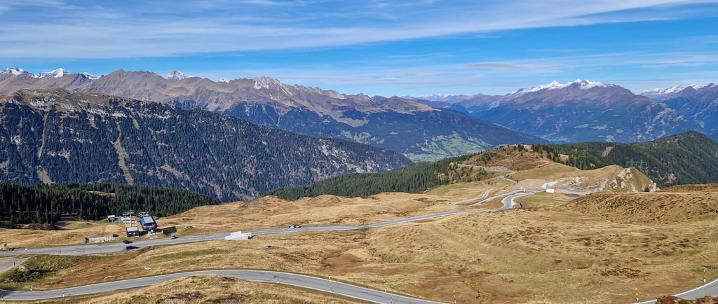 Kurvenreiche Bergstrasse durch die malerische Alpenlandschaft der Dolomiten unter blauem Himmel