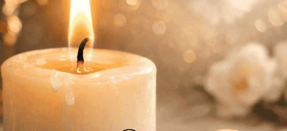 A glowing white candle flame beside gold wedding rings for African spirituality marriage rituals.