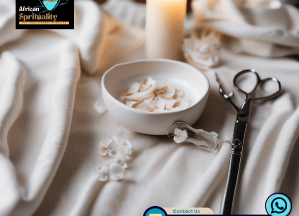 A white ritual bowl with petals next to a lit candle and scissors for spiritual ceremonies.