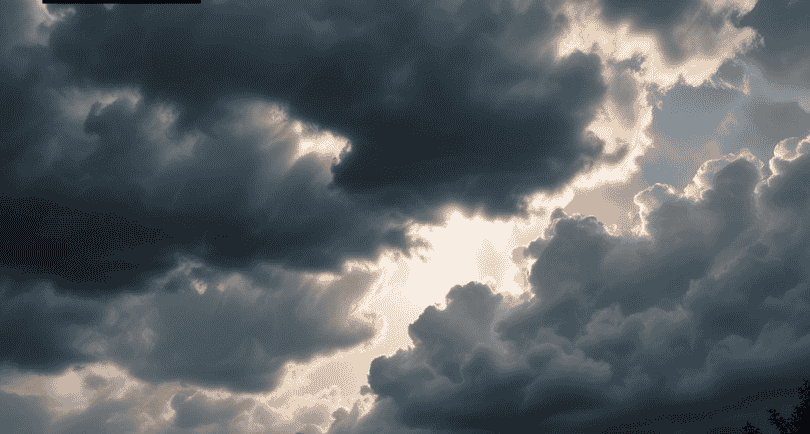 Dramatic dark storm clouds with sun rays for African Spirituality ritual services.